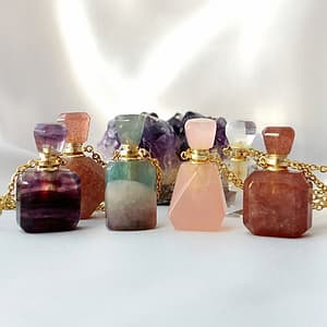 Pink and purple gemstone pendant necklaces with gold chains, displayed on a white background.